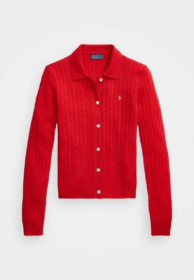 Rød strikket cardigan med kabelmønster, med kragehals, hvite knapper og en liten logo på venstre side. Strukturtstoff.