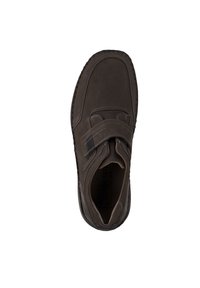 Zapato de ante marrón con una correa de velcro, detalles de costura y una plantilla texturizada. La suela tiene una forma redondeada y un mínimo dibujo.