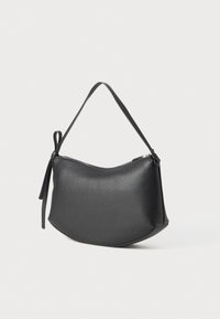 Borsa a tracolla nera in pelle con forma curvata, cintura singola e chiusura con zip. Presenta un dettaglio decorativo annodato sul lato. Texture liscia.