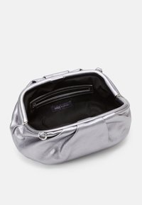 Sølvmetallic taske med en blød tekstur, rund form og en indvendig lomme. Foret med sort stof, prydet med et logomærke.