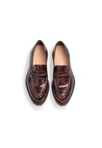 Mocassini in pelle bordeaux con texture goffrata a coccodrillo, dettagli con fascia elastica e suola spessa a contrasto. Progettati per essere indossati senza fare fatica.