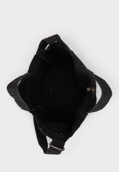 Sac en tissu noir avec un extérieur texturé, des bretelles larges et une ouverture sur le dessus révélant un intérieur spacieux et une petite poche interne.