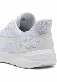 Biały but sportowy z siateczkową cholewką, gładkimi syntetycznymi akcentami, wyściełanym kołnierzem oraz teksturowaną podeszwą z detalem logo na pięcie.