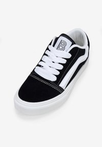 Zapatillas de ante negro con acentos y cordones blancos, que presentan una puntera redonda, suela plana y detalles cosidos. Logo en la lengüeta.