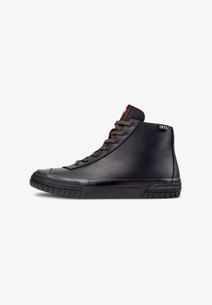 High-top sneakers made of black leather with brown laces, rubber sole, and a red tag labeled "1975" on the ankle. Smooth texture.