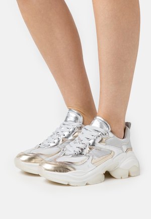Sneaker chunky argento e bianchi con dettagli in rete e metallici, dotate di colletto imbottito e suola in gomma spessa.