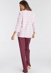 Lightweight pajama set featuring a white top with pink horizontal stripes and maroon pants. The top has three-quarter sleeves and a relaxed fit.