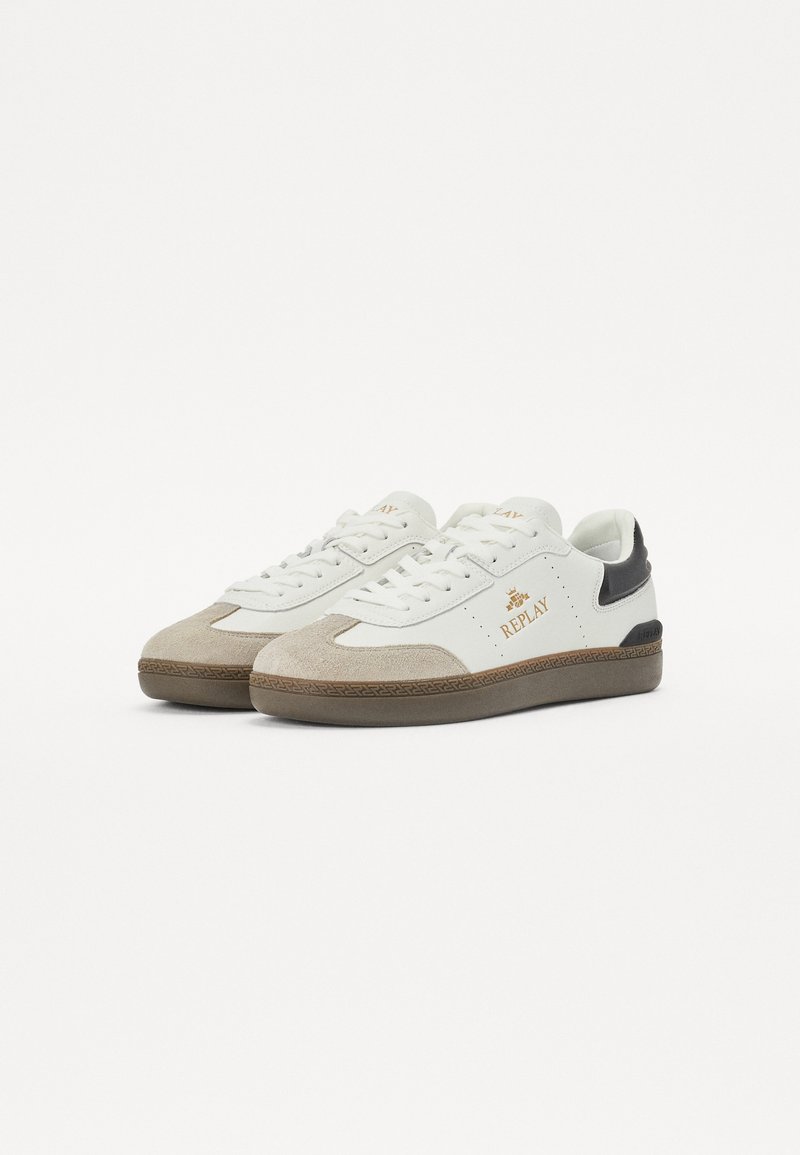 Weiße Sneakers mit beigefarbenen Wildlederakzenten, strukturierten Gummisohlen, Schnürdesign und goldenen Logodetails an der Seite. Schwarzer Kontrast an der Ferse.