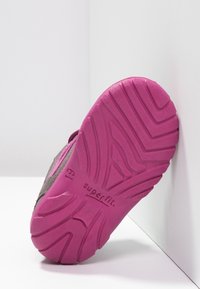 Schoenenzool van helder roze rubbermateriaal, met een loopprofiel. De zijkant toont een grijze bovenkant en het "superfit"-merk in reliëf op de zool.