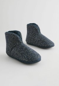 Chaussons bleu foncé à hauteur de cheville fabriqués en tissu tricoté texturé avec une doublure intérieure douce et une semelle rembourrée.