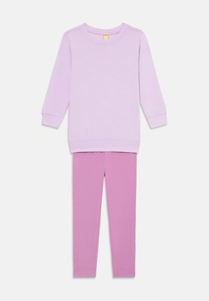 Completo da casa per ragazze composto da due pezzi con maglia a maniche lunghe color lavanda e leggings aderenti rosa su sfondo bianco.