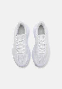 Chaussures de sport blanches en maille respirante, avec un design à lacets, un col rembourré et une semelle texturée pour l'adhérence.