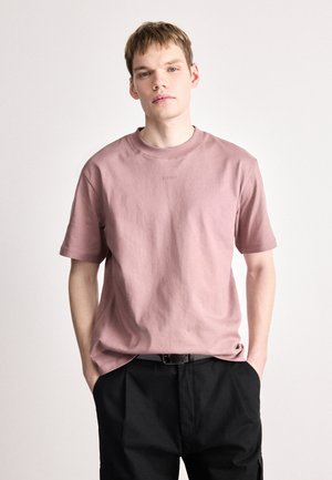 Heledad roosa lühikeste varrukatega T-särk, mis on valmistatud puuvillast, millel on ümmargune kaelus ja väike tikitud "HUGO" logo rinnal.