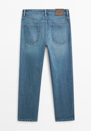 Jeans in denim blu mostrati da dietro con due tasche posteriori e una toppa di marca in pelle marrone sulla vita.