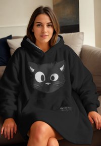 Felpa nera con cappuccio caratterizzata da un design di faccia di gatto in stile cartone animato, con grandi occhi bianchi e baffi, realizzata in materiale morbido, indossata in modo casual.