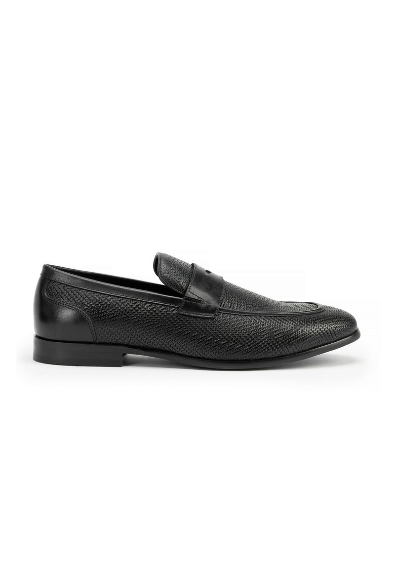 Mocasines de cuero negro con un upper texturizado, puntera redondeada y una correa única en el empeine. Diseño sin cordones con un tacón bajo.