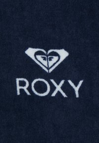 Marinblått tyg med en strukturerad yta, försedd med en vit hjärtlogotyp och ordet "ROXY" under i fet, tydlig stil.