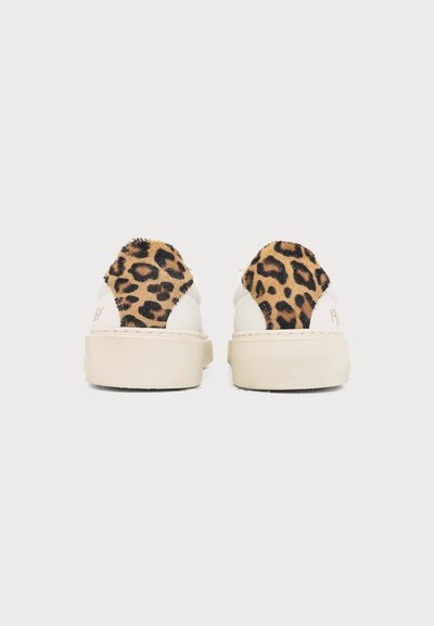 Paire de baskets blanches avec des semelles épaisses beige et un patch imprimé léopard au talon, vues de dos sur un fond uni.