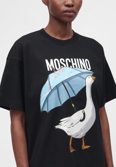 Μαύρο T-shirt με μια λευκή χήνα που κρατάει μια μπλε ομπρέλα και το κείμενο "MOSCHINO" πάνω από την απεικόνιση.