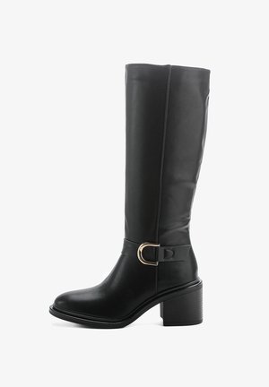 Bottines noires à hauteur de genoux en matériau synthétique lisse, dotées d'un talon carré, d'une accent avec une boucle dorée, et d'un design à bout rond.