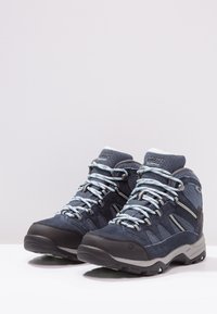 Dunkelblaue Wanderschuhe mit einem Obermaterial aus Wildleder und Mesh, grauen Gummisohlen, hellblauen Schnürsenkeln und gepolstertem Knöchelstütz.