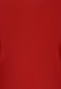 Czerwony materiał o gładkiej, teksturowanej powierzchni, charakteryzujący się jednolitym kolorem bez wzorów czy akcentów. Głównie ma solidny i nieprzezroczysty wygląd.