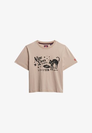 Lysebeige bomulds-T-shirt med korte ærmer, med et sort print af en kat og teksten "Nine Lives Vinyl."