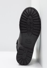 Czarny botek za kostkę z grubą gumową podeszwą, wyposażony w bieżnik zapewniający przyczepność. Na dolnej części znajduje się logo marki i numer rozmiaru.