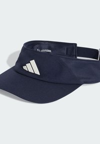 Granatowy daszek wykonany z oddychającego materiału z zakrzywionym rondem. Na przedniej części znajduje się biały akcent z logo Adidas. W zestawie regulowany pasek.