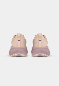 Ανοιχτό ροζ αθλητικά παπούτσια με υφή στο πάνω μέρος, ενισχυμένο κολάρο και αντίθεση μωβ λεπτομέρεια στη φτέρνα. Παχύ, μαλακό πέλμα.