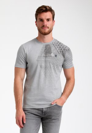 Camiseta gris de manga corta con un diseño de patrón geométrico en un lado, textura suave, cuello redondo y un pequeño detalle de logo.