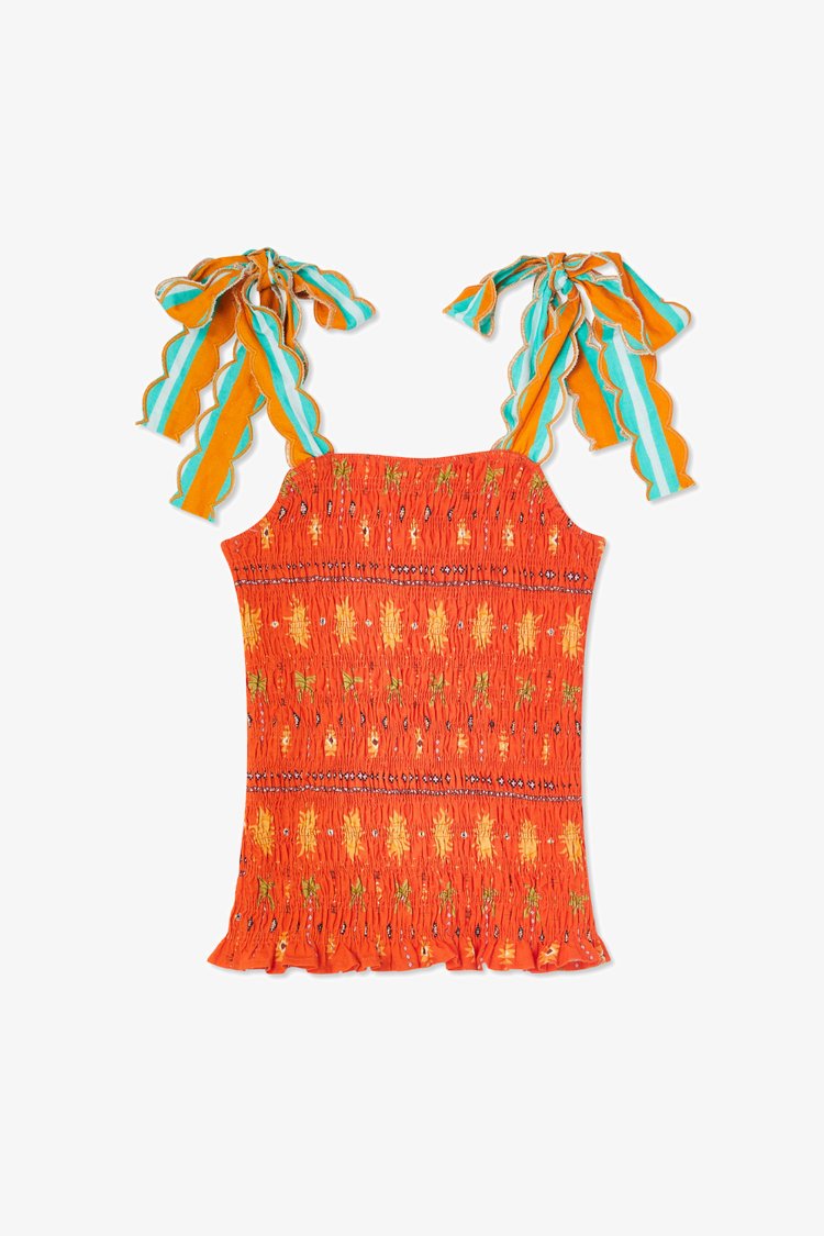 Top smocké orange à motif, avec des liens rayés bleus et oranges. Ourlet froncé avec des accents floraux sur tout le tissu.