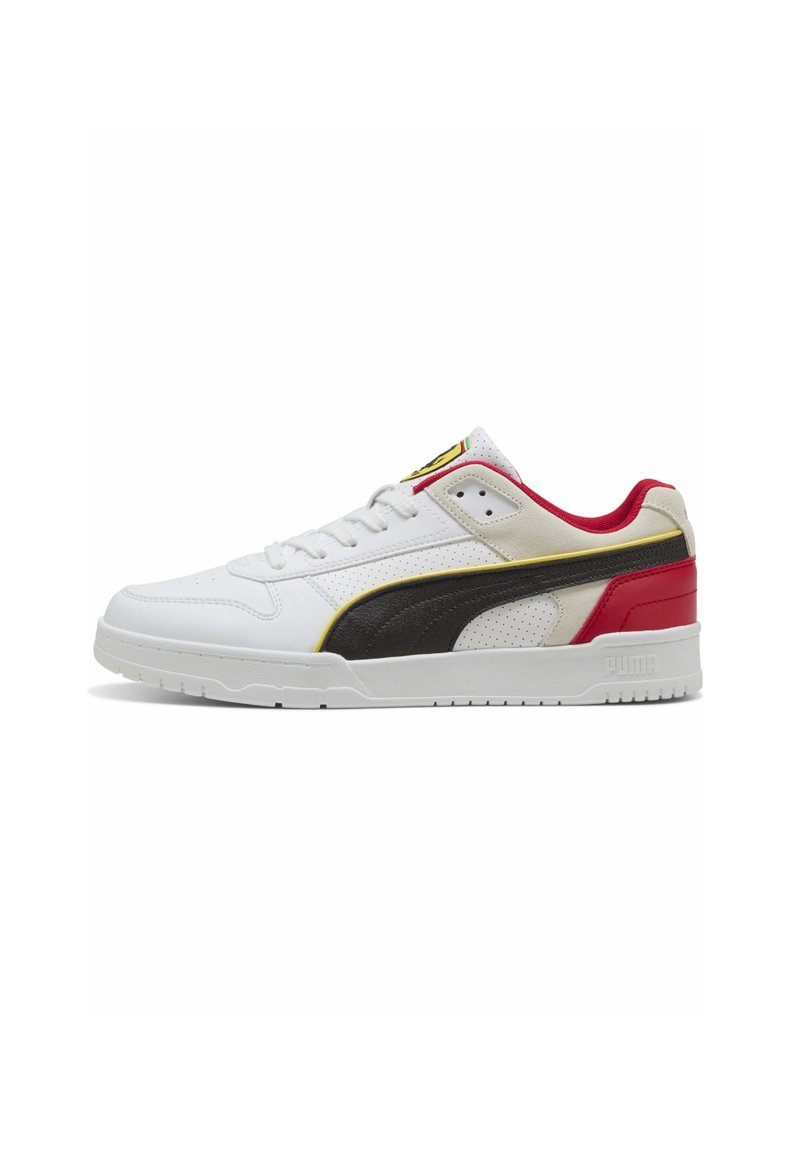 Hvid sneaker med en sort læderstribe, røde og gule detaljer, perforeret design og en struktureret gummisål. PUMA-logo på hælen.