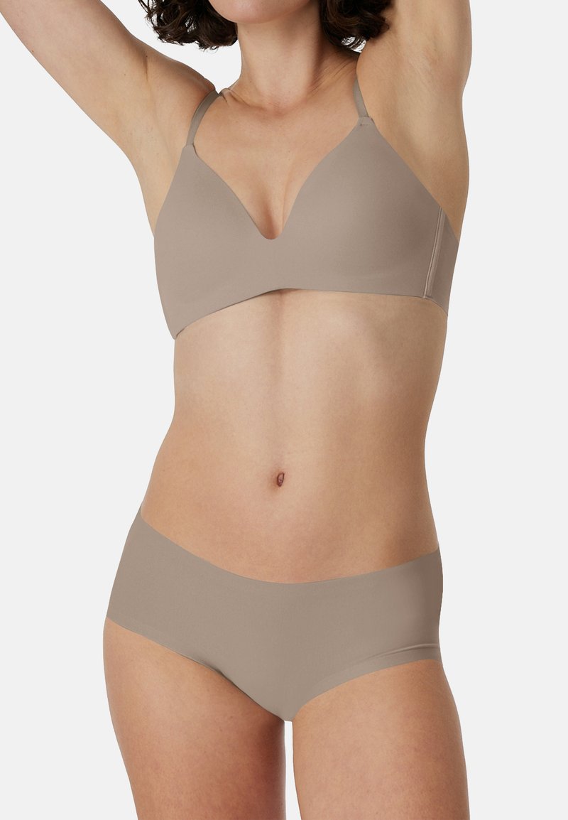 Beige seamless bralette with adjustable straps and plunging neckline, paired with beige hipster panties, soft texture, minimal hardware.