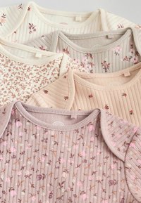 Cinque body per neonati a coste nei toni beige chiaro, crema, pesca e taupe con piccoli motivi floreali disposti sovrapposti.
