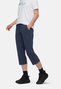 Marina kortbyxor i lätt, stretchig tyg med två sidofickor och logodetalj. Kombineras med en vit grafisk t-shirt och svarta sneakers.