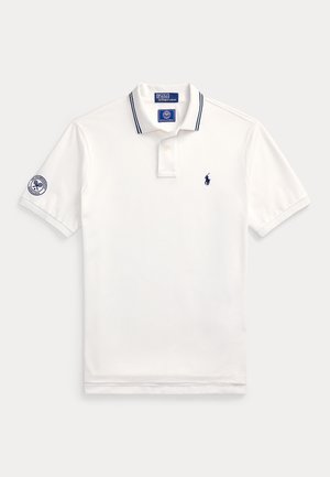 White short-sleeve polo shirt with navy blue details, Ralph Lauren logo on chest, and Wimbledon tennis tournament patch on left sleeve.