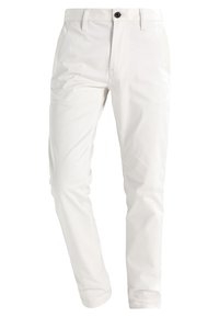 Vita bomullshängselbyxor med rak ben-design, med en enda svart knappstängning, bältesöglor och sidofickor. Slät textur.