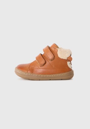Brown toddler shoe with two Velcro straps, rubber sole, fleece lining, and animal face detail on the heel.