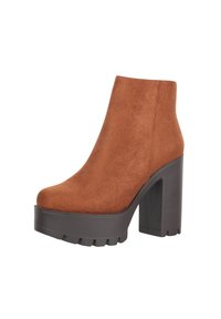 Braune Wildleder-Ankle-Boots mit einer klobigen schwarzen Plateausohle. Sie verfügen über eine glatte Textur und eine abgerundete Zehenpartie sowie einen Schaft in mittlerer Höhe.