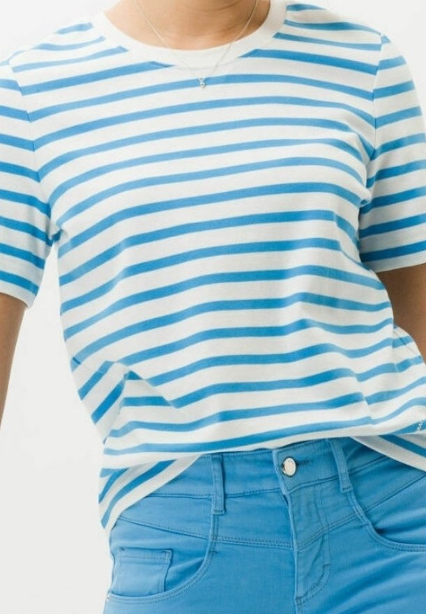 Raidallinen t-paita valkoisena ja vaaleansinisena, valmistettu pehmeästä puuvillasta. Pyöreä pääntie ja lyhyet hihat. Yhdistetty vaaleansinisiin farkkuihin, joissa on etupainike.