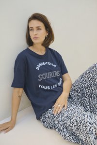 Tricou din bumbac de culoare bleumarin, cu text imprimat alb, asortat cu pantaloni lejeri cu model în nuanțe de bleumarin și alb, având un brâu elastic.