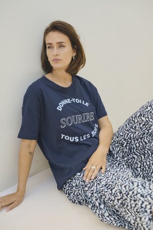 Navy blue cotton t-shirt with white printed text, paired with loose-patterned pants in navy and white tones, featuring an elastic waistband.