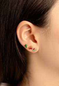 Orecchini in tono oro con tre design: una tartaruga con gemma verde, un granchio rosso e una fetta rossa e verde adornata con piccole pietre.