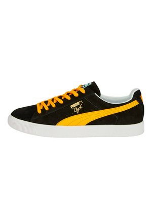 Zwarte suède sneakers met felgele accenten, ronde veters en een witte rubberen zool. Bevat gestructureerde zijstrepen en logo-detail.