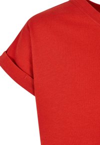 Camisa roja de algodón de manga corta con puño enrollado y cuello en V, mostrada desde el hombro hasta la mitad del pecho.