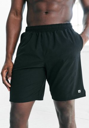 Black athletic shorts with an elastic waistband, side pockets, and a small logo accent. Made from lightweight, smooth fabric.