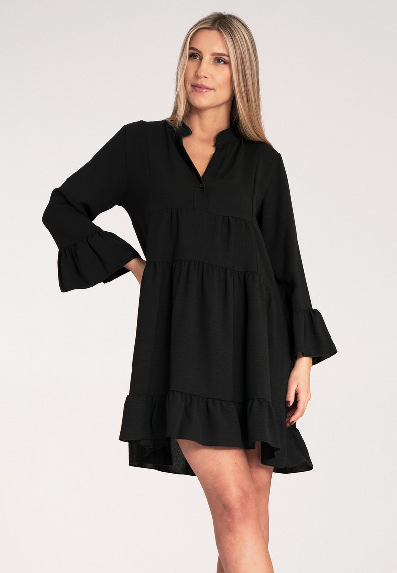 Czarna, warstwowa sukienka z kołnierzykiem, długimi rękawami i falbaniastymi mankietami. Charakteryzuje się zwiewną sylwetką i miękkim, teksturowanym materiałem.
