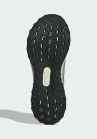 Čierna gumená podrážka s multidirekcionálnymi trakčnými štuple, béžová medzipodrážka a zelená horná časť. Kruhový detail loga na medzipodrážke.