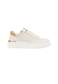 Zapatilla blanca con una textura suave, acentos de cuero marrón en el talón, ojales dorados y una gruesa suela de goma blanca. Diseño minimalista.